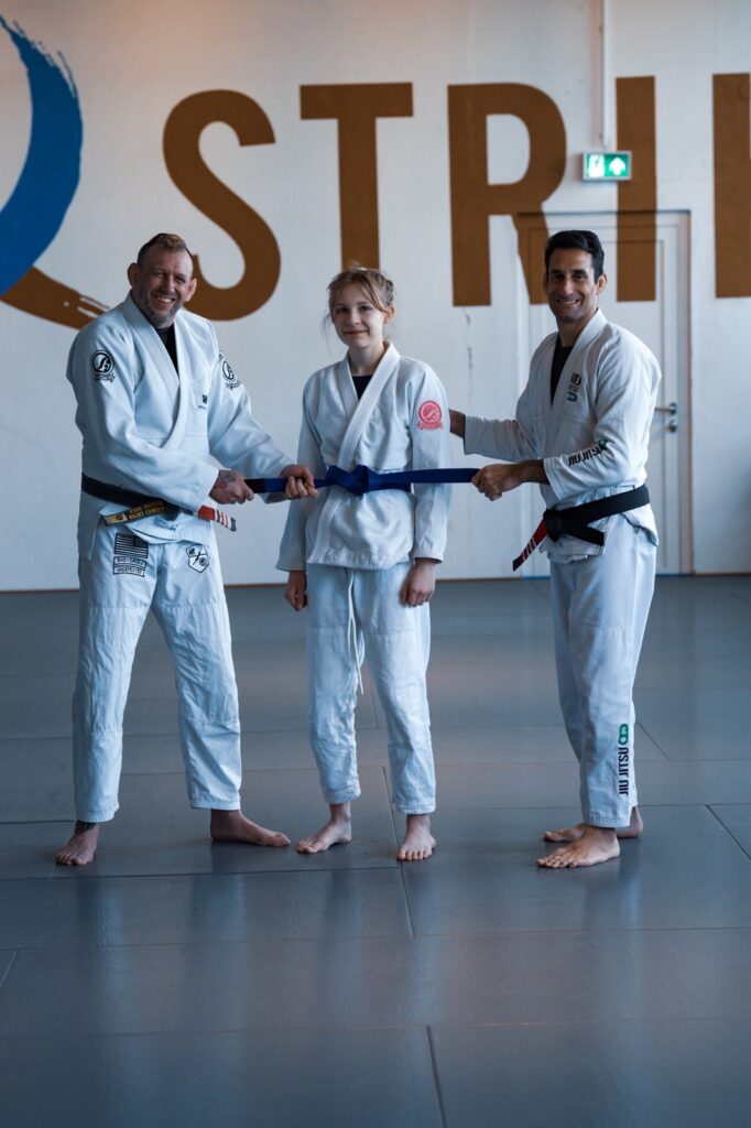 Clara bekommt ihren Blaugurt von Henning Bode und Gabriel Rollo