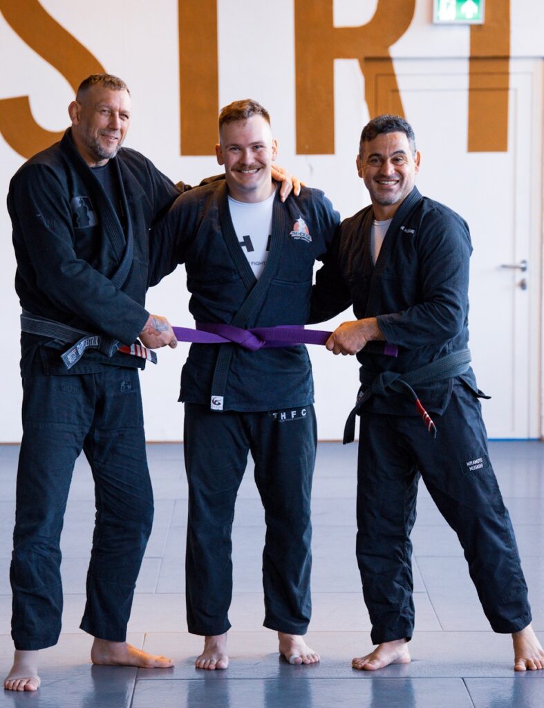Trainer Henning steht links, neuer Purple Belt Steffen in der Mitte und Trainer Thiago recht.